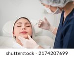 Small photo of Beautiful young Asian woman getting cosmetology treatment facial skin injection by doctor beautician in beauty clinic. Female making mesotherapy beauty care with anti-aging of face in surgery clinic.