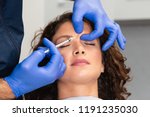 Close up of beautician expert's hands injecting botox in female forehead.