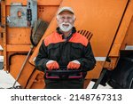 Small photo of Portrait of a mature worker of the city utility company. Garbage collector.