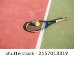 Tennis ball and racket on the court. Hard cover.