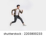 Full length Asian man running jumping in air gesture with happy smile on isolated white background. Cool man joyful running in copy space. Studio short.