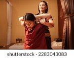 Asian woman customer get service Thai massage of stretching for treat painful from office syndrome with masseur in spa salon. Thai massage with masseur in spa salon.