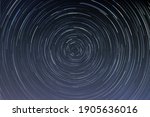 Star trails in a night sky, long exposure style realistic circular star arcs pattern, star motion due to Earth