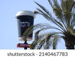 Small photo of ISRAEL. Rishon Le Zion. 20 March 2022: AROMA sign on the shope building near palm tree. AROMA Logo. A popular chain of coffee houses throughout the country. Giant cup of coffee. Coffee to go