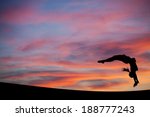 Small photo of silhouetted gymnast doing a back handspring in sunset sky