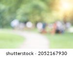 Defocusd park and people bokeh background with orange light, blurre road, green grass and tree background.