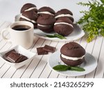 Small photo of Whoopie pie served on several round plates decorated with pieces of chocolate and a coffee cup.