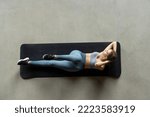 Small photo of Top view of sporty woman doing cross training bicycle crunches trains leg muscles and abs. Athlete conducts daily training on a mat in the room.