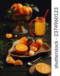 Small photo of Juicy orange tangerines and tangerine juice in a jar on an old wooden table