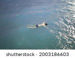 Small photo of Body of a man floating in the ocean. The lifeless body of a man in the water. Drowned at sea in stormy weather.