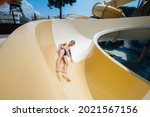 A happy boy of seven years old descends from the slides in the water park. Happy vacation vacation. Summer holidays and tourism.