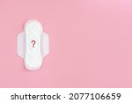 Small photo of Сlean feminine sanitary napkin with question mark. Absence of menstruation in woman. Minimal concept of female menopause. Copy space
