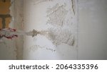 Small photo of Machine application of mortar to the wall. Machine application of plaster to the wall. Plasterer throws plaster on the wall. Plastering walls in a new house.