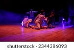 Small photo of Dance group on a professional stage with light. Girls on stage, hugging, theatrical production. Modern dance moves, on stage.