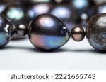 Small photo of Defocused macro abstract texture background of a dark blue and black baroque pearl necklace with natural surface scarring and aberrations