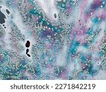 Close up abstract texture view of a car windshield in an automatic car wash, with colorful soap and water droplet designs