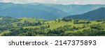 Blue mountains, green valley. Panoramic view of Ukrainian mountains in summer day. Carpathian, Ukraine, Europe. Mountain tourism. Tourism and travel concept. Natural green forest background panorama. 