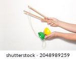 Small photo of Hands holding a diabolo and two sticks to juggle on a white background