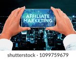The concept of business, technology, the Internet and the network. Business lady looks at the virtual screen of your smartphone and sees the inscription: Affiliate marketing