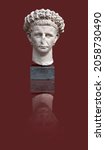 Small photo of Copy of an antique sculptural portrait of the Roman emperor Claudius isolated on a red background. Design element with clipping path