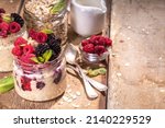 Small photo of Healthy Homemade Overnight Oats Oatmeal with berry. Portioned Oatmeal porridge with fresh raspberry ans blackberry in a glass jar. Healthy summer breakfast
