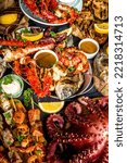 Small photo of Assortment various barbecue Mediterranean grill food - fish, octopus, shrimp, crab, seafood, mussels, summer diet bbq party fest, with kebab, sauces, black concrete background, above copy space