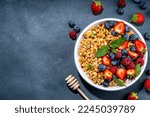 Healthy breakfast granola with fresh berry - strawberry, raspberry, blueberry on black background