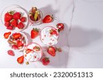 Small photo of Rhubarb and strawberry milkshake or smoothie, refreshing summer drink, Healthy dieting and antioxidant summer beverage with whipped cream, fresh rhubarb, strawberry slices, on white kitchen table