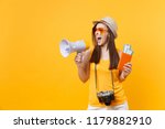 Expressive tourist woman in summer casual clothes hat holding megaphone passport tickets isolated on yellow orange background. Female traveling abroad to travel weekends getaway. Air flight concept