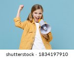 Joyful little blonde kid girl 12-13 years old in yellow jacket posing isolated on pastel blue background. Childhood lifestyle concept. Mock up copy space. Screaming in megaphone doing winner gesture