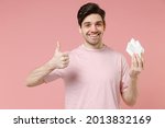 Small photo of Sick ill ailing allergic man has red eyes runny nose suffer from allergy hold paper napkin isolated on pastel pink color wall background studio Healthy lifestyle disease treatment cold season concept