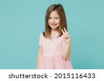 Little funny cute kid girl 5-6 years old wears pink dress show victory v-sign gesture isolated on pastel blue color background child studio portrait. Mother's Day love family people lifestyle concept