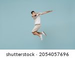 Small photo of Full length young man 20s in casual white t-shirt jump high doing dab hip hop dance hands move gesture youth sign hide cover face isolated on plain pastel light blue color background studio portrait.