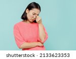 Small photo of Young pensive sad woman of Asian ethnicity 20s wearing pink sweater keep eyes closed rub put hand on nose isolated on pastel plain light blue color background studio portrait. People lifestyle concept