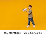 Full body little small smiling happy boy 6-7 years old in green t-shirt hold scream in megaphone announces discounts sale Hurry up isolated on plain yellow background. Mother's Day love family concept