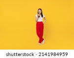 Full size body length young girl woman of Asian ethnicity 20s years old in casual clothes hold takeaway delivery craft paper brown cup coffee to go isolated on plain yellow background studio portrait