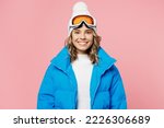 Snowboarder smiling happy woman 20s wear blue suit goggles mask hat ski padded jacket spend extreme weekend look camera isolated on plain pastel pink background. Winter sport hobby trip relax concept