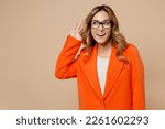 Small photo of Young curious nosy employee business woman corporate lawyer wear classic formal orange suit glasses work in office try to hear you overhear listening intently isolated on plain beige background studio