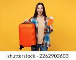 Small photo of Traveler happy woman wear casual clothes hold valise passport ticket isolated on plain yellow background studio. Tourist travel abroad in free spare time rest getaway. Air flight trip journey concept