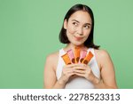 Young fun happy woman wear white clothes hold in hand many protein bars look aside on area isolated on plain pastel light green background. Proper nutrition healthy fast food unhealthy choice concept