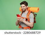 Small photo of Young fun traveler white man carry backpack stuff mat use mobile phone isolated on plain green background Tourist leads active healthy lifestyle walk on spare time Hiking trek rest travel trip concept