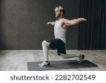 Small photo of Full body young strong sporty athletic sportsman man wearing white tank shirt black shorts leggings do squat lunges with outstretched hands at floor warm up train indoor at gym. Workout sport concept