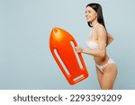 Small photo of Side view young fun lifeguard woman wear swimsuit near hotel pool hold in hand lifebuoy run fast hurry up isolated on plain pastel light blue cyan background. Summer vacation sea rest sun tan concept