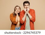Small photo of Young shocked scared fearful couple two friends family man woman wear casual clothes looking camera biting nails fingers together isolated on pastel plain light beige color background studio portrait