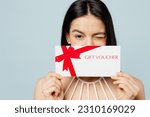 Small photo of Young woman wear swimsuit hold cover eye with store gift certificate coupon voucher card wink near hotel pool isolated on plain pastel light blue background. Summer vacation sea rest sun tan concept