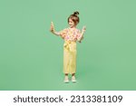 Full body little child kid girl 6-7 years old wear casual clothes doing selfie shot on mobile cell phone e show v-sign isolated on plain green background. Mother's Day love family lifestyle concept