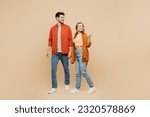 Small photo of Full body young couple two friends family man woman wear casual clothes together point thumb finger aside indicate on workspace area copy space mock up isolated on pastel plain beige color background