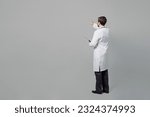 Full size male doctor happy cheerful man wears white medical gown suit work in hospital hold clipboard with paper documents isolated on plain grey color background studio. Healthcare medicine concept