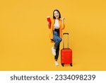 Small photo of Young woman wears summer clothes hold passport ticket suitcase do winner gesture isolated on plain yellow background. Tourist travel abroad in free time rest getaway. Air flight trip journey concept