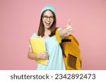 Blinking young woman student in blue t-shirt hat glasses backpack hold notebooks showing thumb up like isolated on pink background studio portrait. Education in high school university college concept